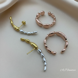 Elemental Echo Trio 925 Silver Three-Tones Earrings set with molten beaded curves in gold, silver, and rose gold, displayed on soft beige satin fabric.