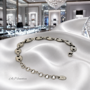 Minimalist Gilded Link Embrace bracelet in silver-hued stainless steel with polished oval links, adjustable extender chain, and lobster clasp on a satin white cloth.