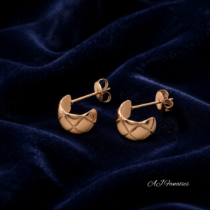 Luxe Lattice Stainless Steel Rose Gold Earrings, small crescent huggie studs with quilted lattice texture, displayed on deep navy velvet fabric.