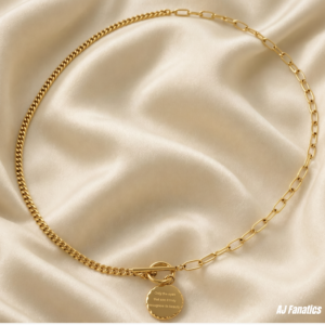 Percepta Vista Necklace from the AJ Fanatics Collection, featuring a dual-link 18K gold stainless steel chain with a front toggle clasp and round pendant engraved with the AJ Fanatics signature logo on one side and the motto ‘only the eyes that see it truly recognise its beauty’ on the other.