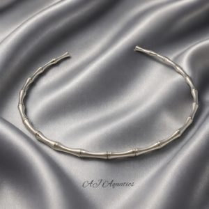 Forest Whisper Stainless Steel Silver Necklace from the Simplicity in Every Curve Collection, shown as an open, bamboo-textured silver collar on a silver silk cloth background.